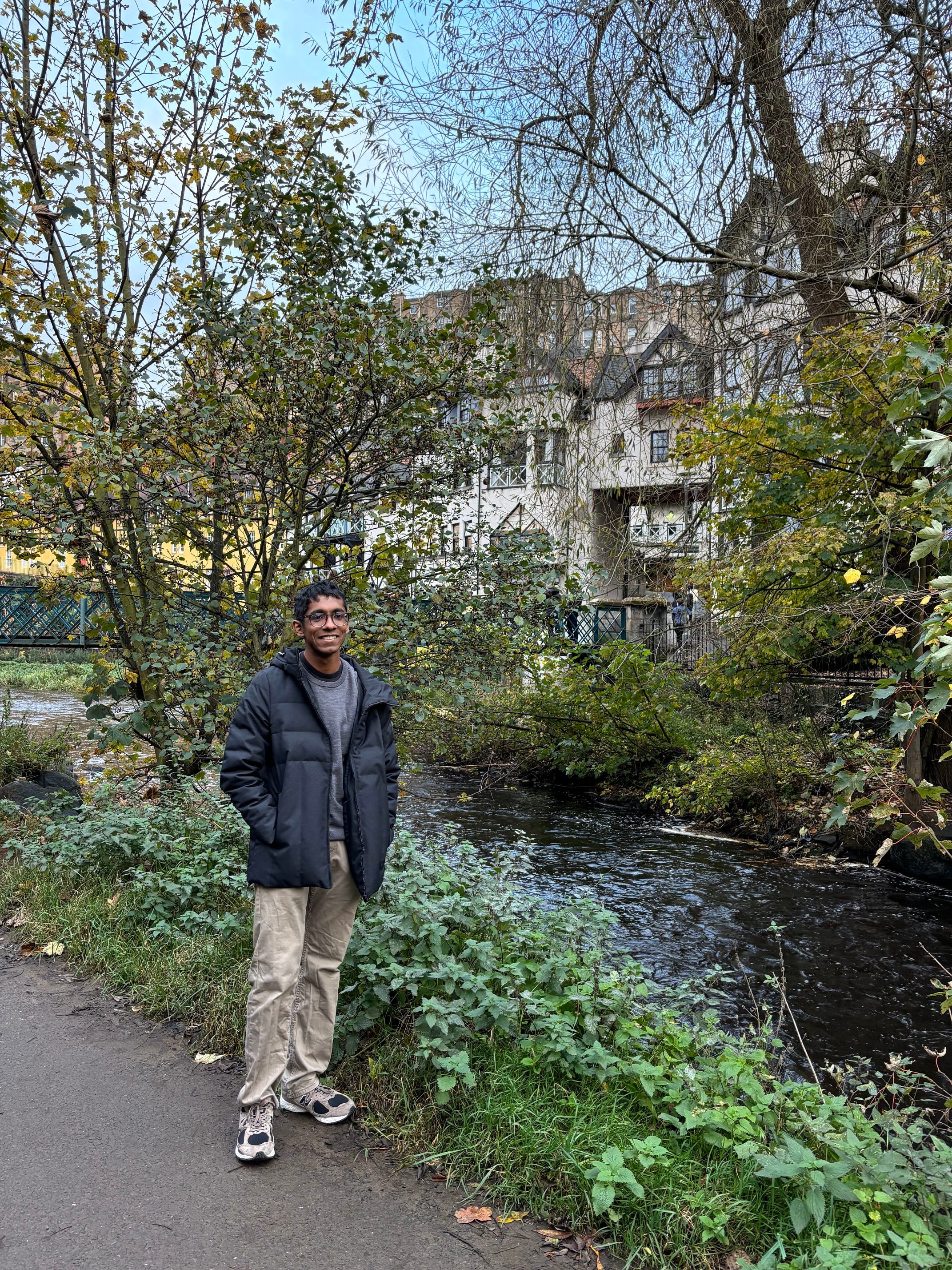 Man in glasses and jacket standing by a lake